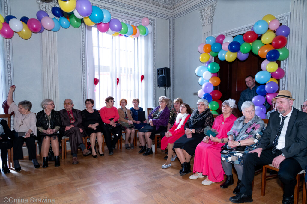 Grupa seniorów siedzi i wspólnie śpiewa