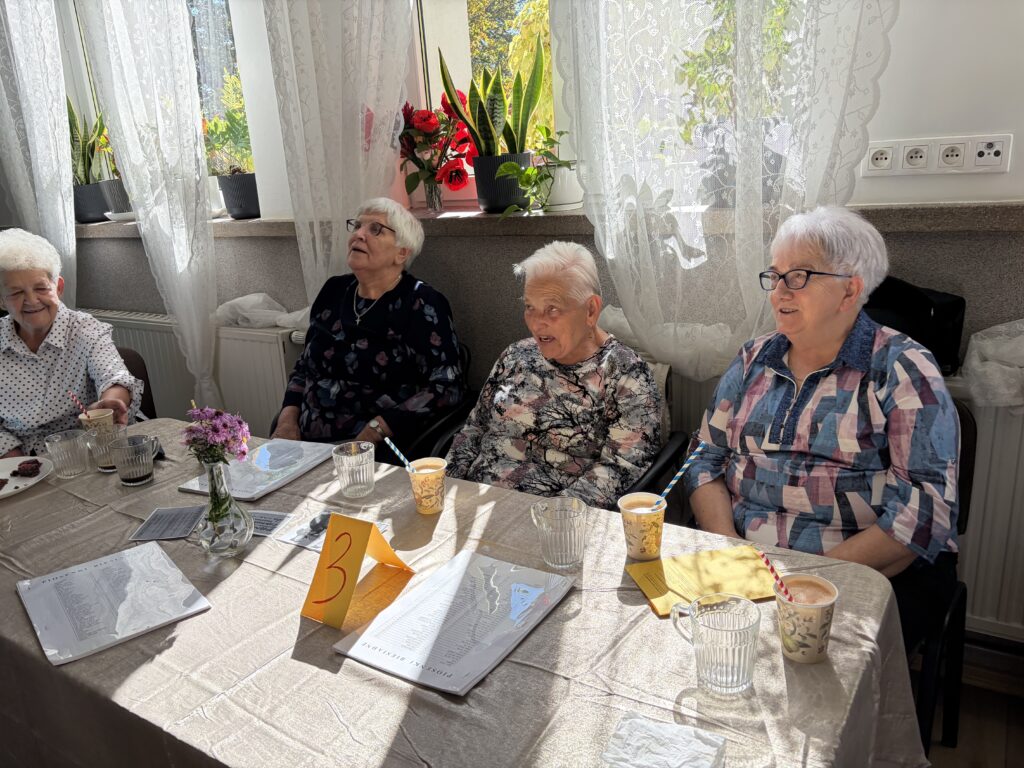 Cztery panie siedzą i śpiewają przy stoliku numer 3